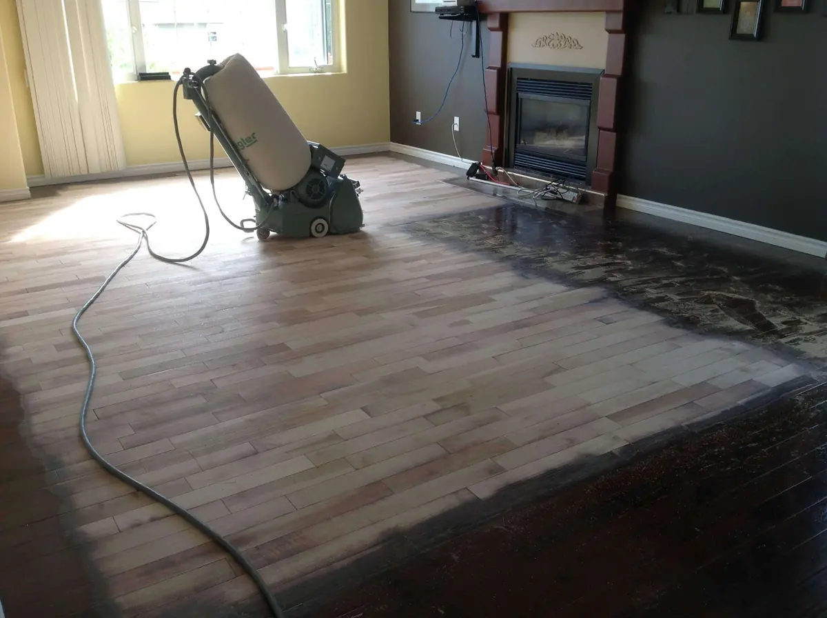 Sanding a living room floor beside the fireplace